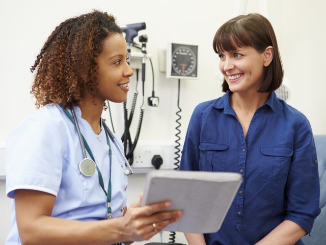 Nurse Showing Patient Test Results On Digital Tablet Nurse Showing Patient Test Results On Digital Tablet
